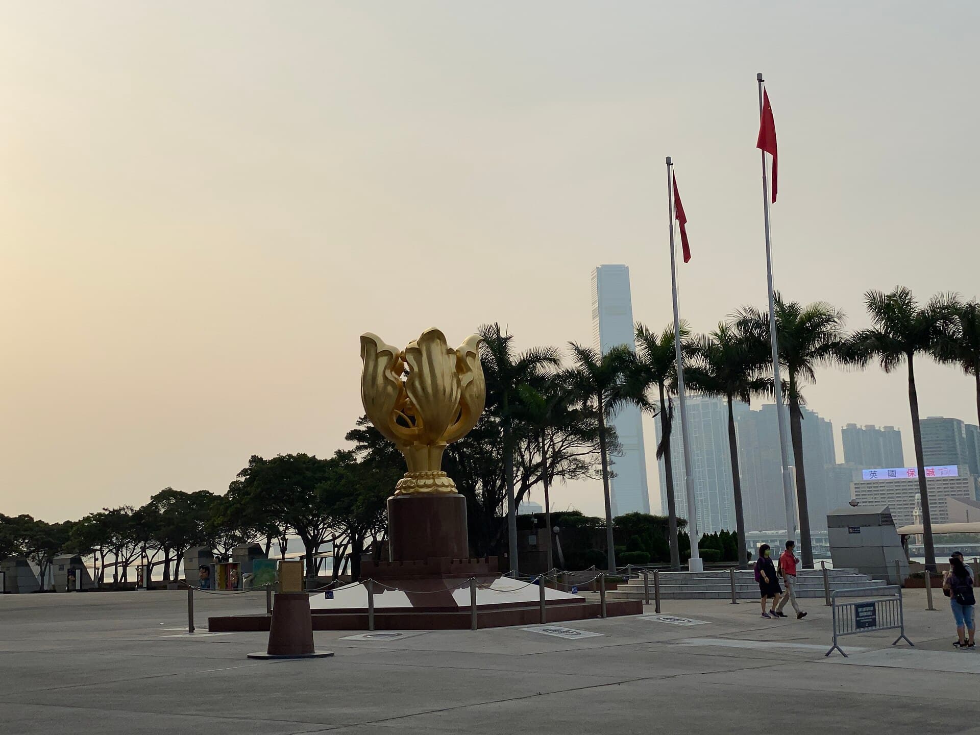 Golden Bauhinia Square with the Forever Blooming Bauhinia sculpture, flags, and Wan Chai harbour skyline